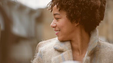 woman with curly hair smiling and thinking about why work-life balance is important